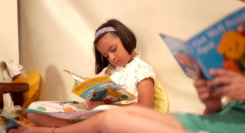 Toddlers reading a storybook at Vishwajyot Preschool